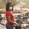 Black woman cleaning up a polluted dump site